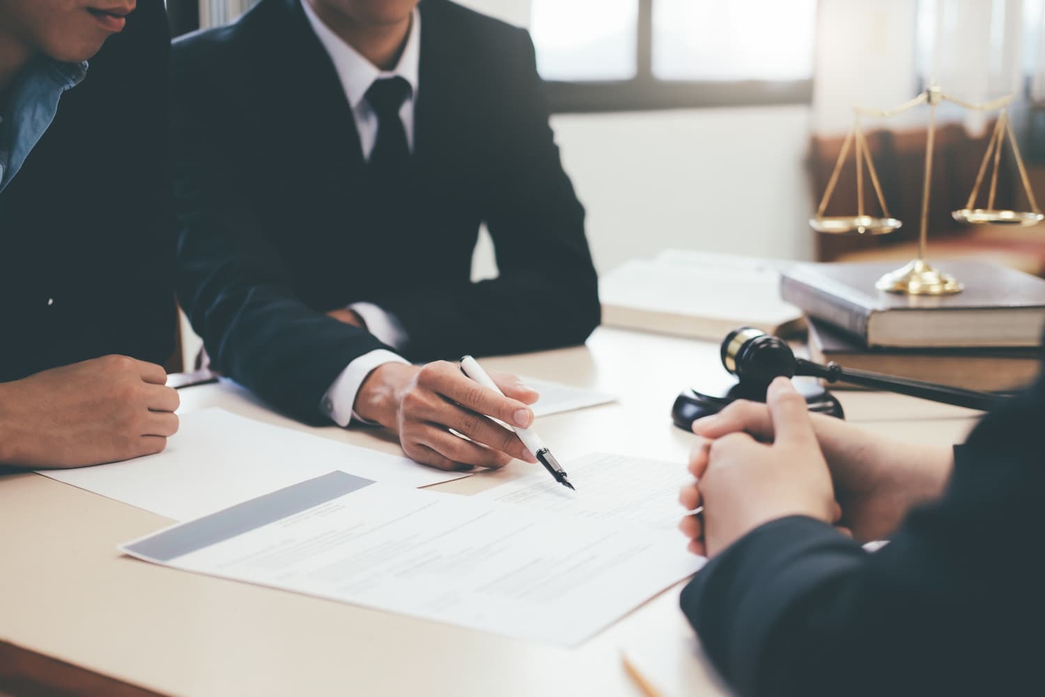 Lawyer advising clients on a legal document in a bright office.